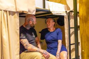 a man and a woman sitting in a bunk bed at Urban Nest Hostel in Santa Ana