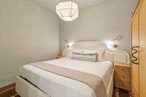 Un dormitorio con una cama blanca y una lámpara. en Hotel Perle, en Nueva Orleans