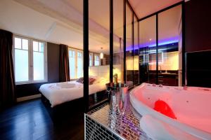 a hotel room with a tub and a bed at Rouen centre - Welcome to Romain in Rouen