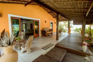 a large living room with a wooden floor and a porch at Refugio pe na areia na Praia do Acuipe com Wi-Fi in Olivença