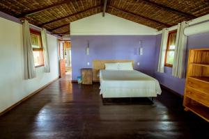 a bedroom with a bed and a purple wall at Refugio pe na areia na Praia do Acuipe com Wi-Fi in Olivença +34 photos