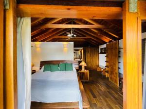 a bedroom with a white bed with green pillows at Aqua Oceanfront Hotel Resort in El Gigante +47 photos