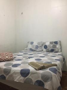 a bed with blue and white sheets and pillows at Casa Aconchegante na praça 14 in Manaus