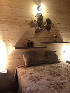 a bedroom with a wooden wall with a bed at Le Chalet in Fanjeaux