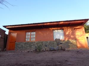 a house with a stone wall and a window at Guest House Diaguitas in San Pedro de Atacama