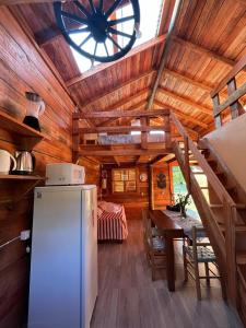 a kitchen with a refrigerator and a clock on the ceiling at Cabana Pôr-do-sol in Torres