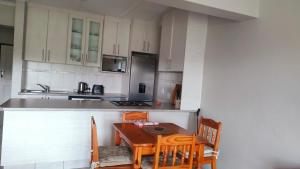 a kitchen with a wooden table and chairs at The Cabanas in Scottburgh