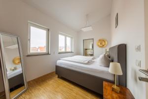 a bedroom with a large bed and a mirror at Hotel Freischütz Apartments in Landshut