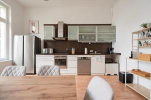 a kitchen with white appliances and a wooden floor at Alster Boho Apartment auf 150qm für bis zu 9 Gäste in Hamburg
