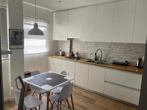 a kitchen with white cabinets and a table and chairs at Excepcional apartamento Art Deco de 3 dormitorios in Montevideo