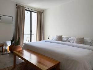 una camera bianca con un grande letto e un tavolo di Casa 821 Guest House a Città di Oaxaca