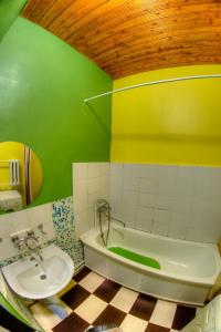 uma casa de banho verde com uma banheira e um lavatório em Yourhostel Olimpiyskiy em Kiev