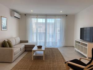 a living room with a couch and a tv at Swieqi Malaika New Apt 6 in Is-Swieqi