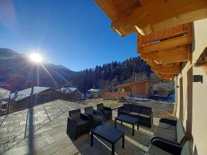 een groep stoelen op een patio met zon bij La grange d'Ernestia in Bourg-Saint-Maurice