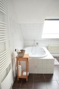 a white bathroom with a tub and a sink at Royal Home - Geräumige Ferienwohnung mit Balkon nahe Seepark Lünen und Dortmund! in Lünen +30 photos