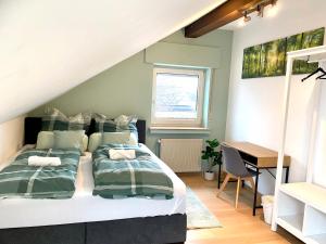 a bedroom with a bed and a desk in it at Royal Home - Geräumige Ferienwohnung mit Balkon nahe Seepark Lünen und Dortmund! in Lünen