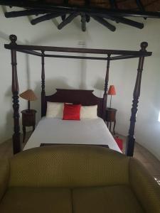 una camera con letto a baldacchino e cuscino rosso di Buchan Estate and Self Catering a Città del Capo Altre 98 foto