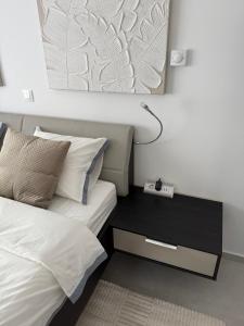 a bedroom with a bed and a night stand with a lamp at Dalma Pro Apartments - Cozy Studio & Spacious One-Bedroom Apartment - Self Check-in in Karlovac