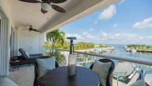 a balcony with a table and chairs and a view of the water at 123 Mariners Club in Key Largo