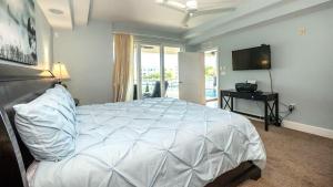 a bedroom with a white bed and a television at 123 Mariners Club in Key Largo