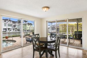 a dining room with a table and chairs and a balcony at Waterfront! Canal View, dock Heated Pool - The Fair View of the Bay - Roelens in Fort Myers Beach
