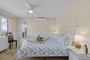 a white bedroom with a bed and a table at Waterfront! Canal View, dock Heated Pool - The Fair View of the Bay - Roelens in Fort Myers Beach +52 photos