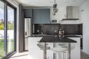 una cucina con bancone nero e sgabelli di Palhais Paradiso - perfect for families & friends a Santo Isidoro