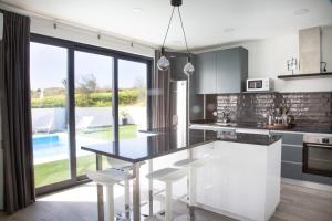 una cucina con tavolo, sedie e piscina di Palhais Paradiso - perfect for families & friends a Santo Isidoro