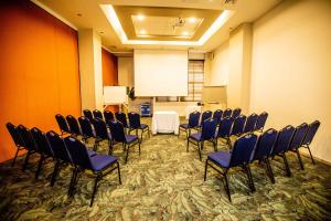 a conference room with chairs and a white table and a screen at Hotel Dann Carlton Cali in Cali