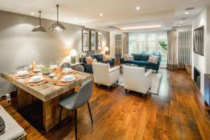 a dining room and living room with a table and chairs at -Air con- Luxury Townhouse - High St Kensington! in London