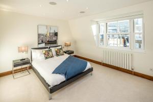a bedroom with a bed and two windows at -Air con- Luxury Townhouse - High St Kensington! in London