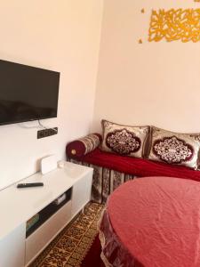 Una sala de estar con un sofá rojo y un televisor de pantalla plana. en Dar Igri, en Ourika