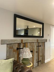 a mirror above a couch in a living room at Cosy Hideaway 7 min from Soho farmhouse in Enstone