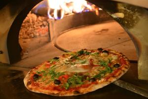 a pizza is coming out of an oven at Hotel Duc De Rohan in Livigno