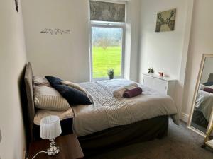 a bedroom with a large bed and a window at Scenic 2Bed Retreat - Gateway to Snowdonia in Llanrwst
