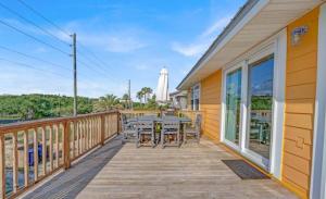 a wooden deck with a table and chairs on it at The Honey Hole St George Island Pet Friendly-Heated Private pool West Gulf beaches in St. George Island