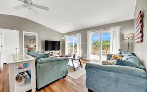a living room with two blue chairs and a television at The Honey Hole St George Island Pet Friendly-Heated Private pool West Gulf beaches in St. George Island
