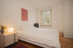 バーゼルにあるTwo Floor Apartment with Garden & BaselCardのベッドと窓のある白い寝室