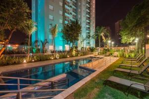 - une piscine avec des chaises la nuit et un bâtiment dans l'établissement AP EXPOCENTER - ATÉ 5 HOSPEDES, à São Paulo
