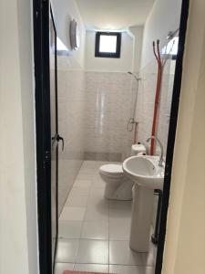 a bathroom with a toilet and a sink at Immeuble Sali-Laye in Diass