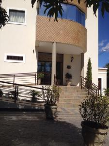 ein Gebäude mit Treppen und Topfpflanzen davor in der Unterkunft Hotel Eden in Sorocaba