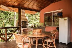 eine Küche mit Tisch und Stühlen auf einer Terrasse in der Unterkunft Sitio Cantinho da Vovó Cida e Vovô Nilson in São João Batista