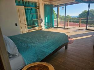 1 dormitorio con cama verde y ventana grande en Wayo ocean view Tamanique house, en Tamanique 14 fotos más