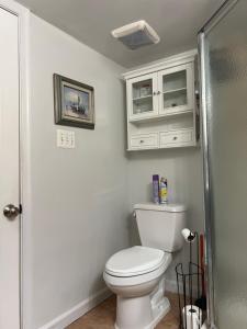 a bathroom with a toilet and white cabinets at Homestay Basement Falls Church in Falls Church +23 photos