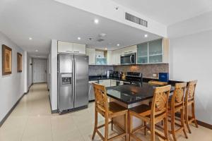 a kitchen with a table and a stainless steel refrigerator at Beachfront - Amber Penthouse 2BR condo - P512 in Palm-Eagle Beach