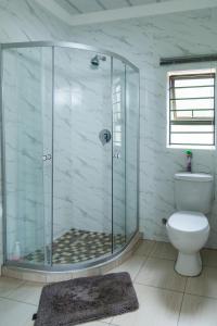 Manna House في فيرينجنغ: حمام مع دش زجاجي ومرحاض