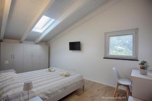 MontaleにあるLa terrazza sul golfoのベッドと窓のある白い寝室