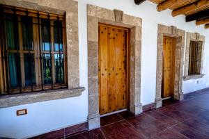 zwei Holztüren an der Seite eines Gebäudes in der Unterkunft Casita Nodin in Cuatrociénegas de Carranza