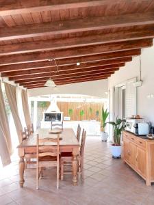 a dining room with a wooden table and chairs at Villa Cuoredimare exclusive use in Cala Sinzias