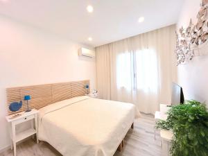 a bedroom with a large bed and a television at Villa Cuoredimare exclusive use in Cala Sinzias